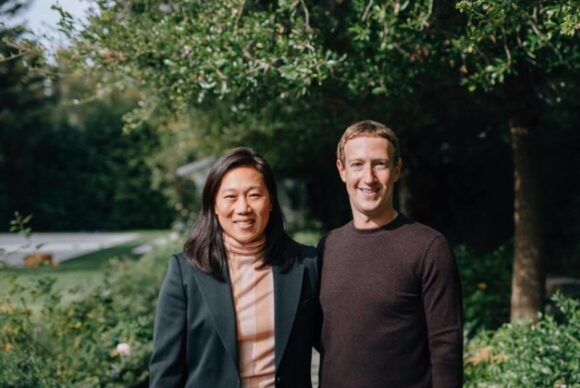 Priscilla Chan and Mark Zuckerberg standing side by side, smiling