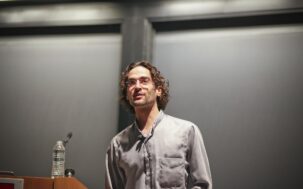 Noah Goodman speaking at a lectern.