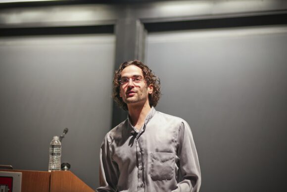 Noah Goodman speaking at a lectern.