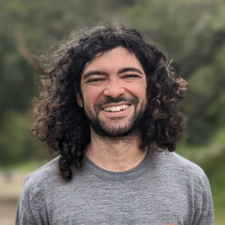 Gabriel Poesia wearing a gray shirt and smiling at the camera.