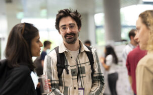 A man in conversation smiling at the camera